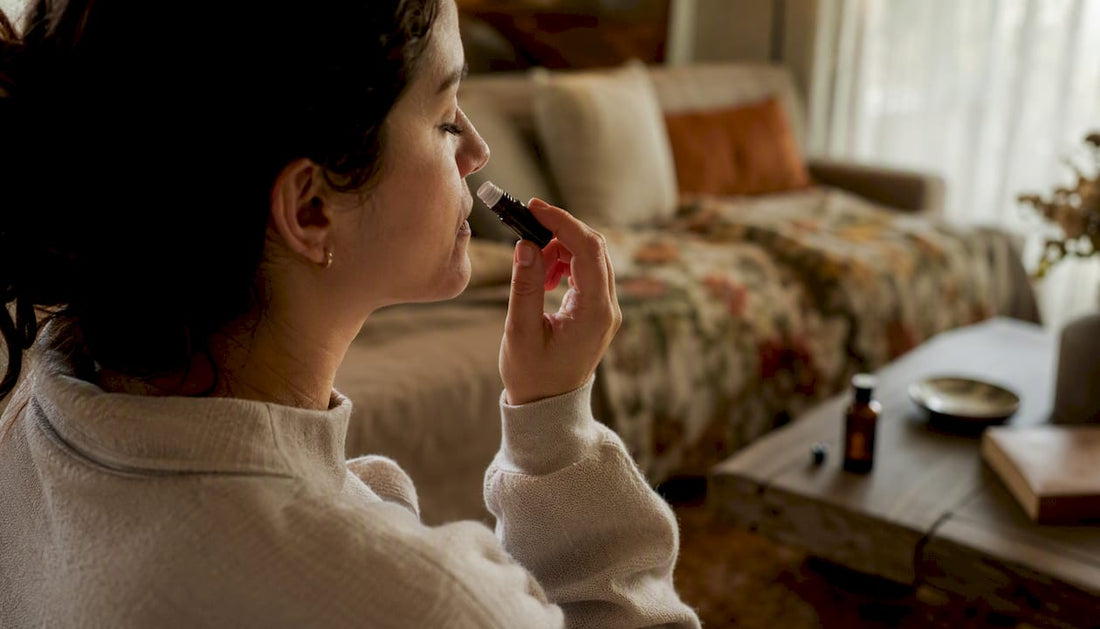 Hand holding essential oil inhaler near nostril