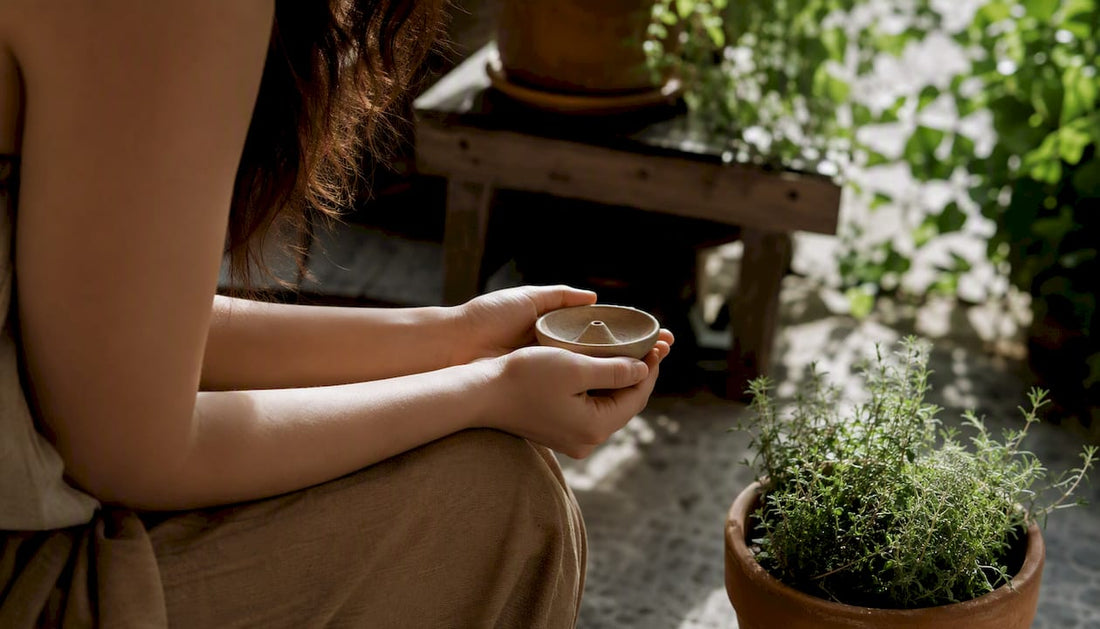 Hands holding smooth ritual object in warm light