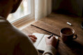 Person writing smoking triggers on notepad