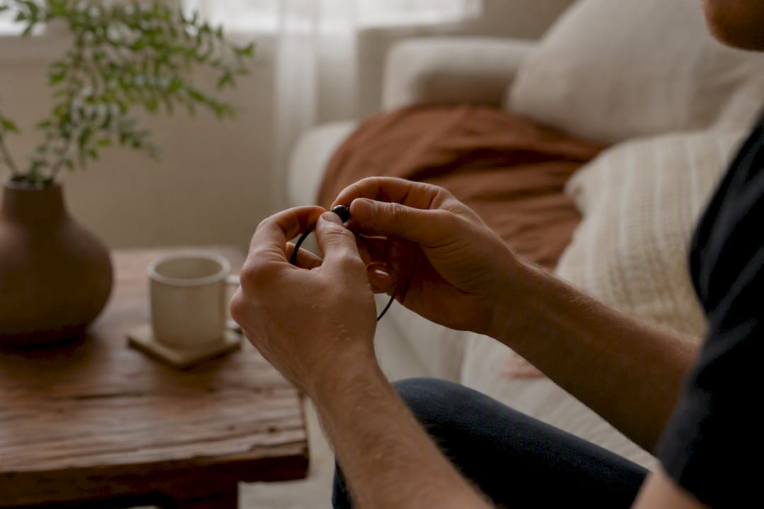Hands holding oral fixation necklace at home